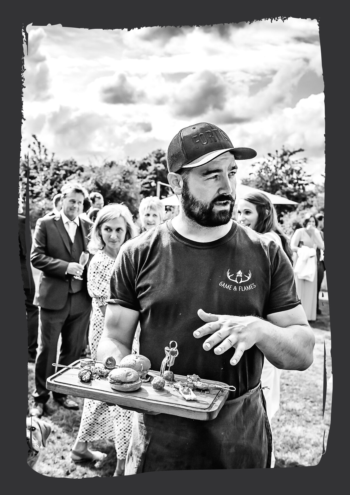 Cai Ap Bryn presenting fire-cooked food to guests at a corporate event - from the official GNF brochure