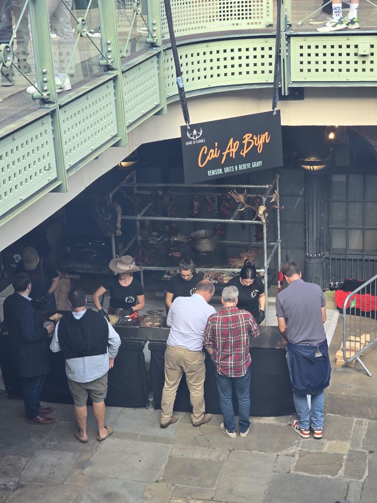 Overhead view of the Game and Flames stand with Cai Ap Bryn sign, crowds queuing