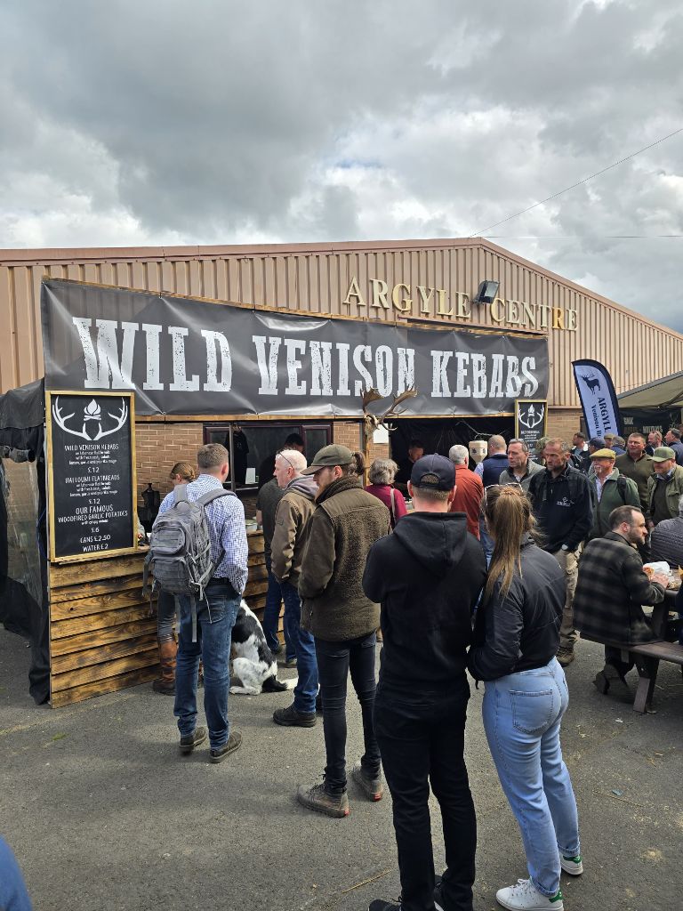 Crowds queuing at the Wild Venison Kebabs stand at a game fair