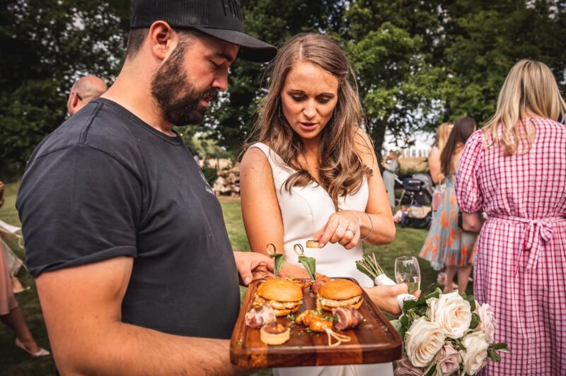 Bride tasting Game and Flames food at wedding