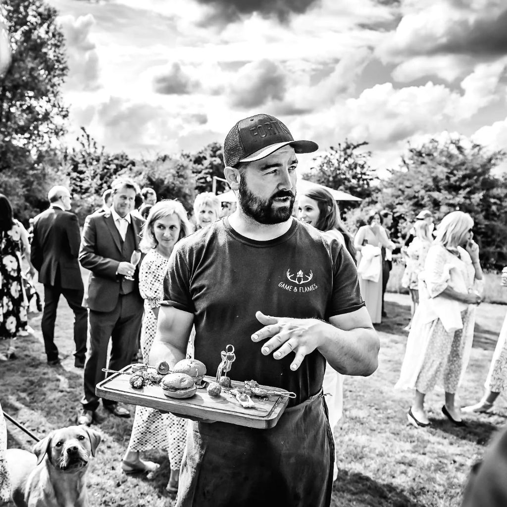 Cai serving canapes to wedding guests in black and white