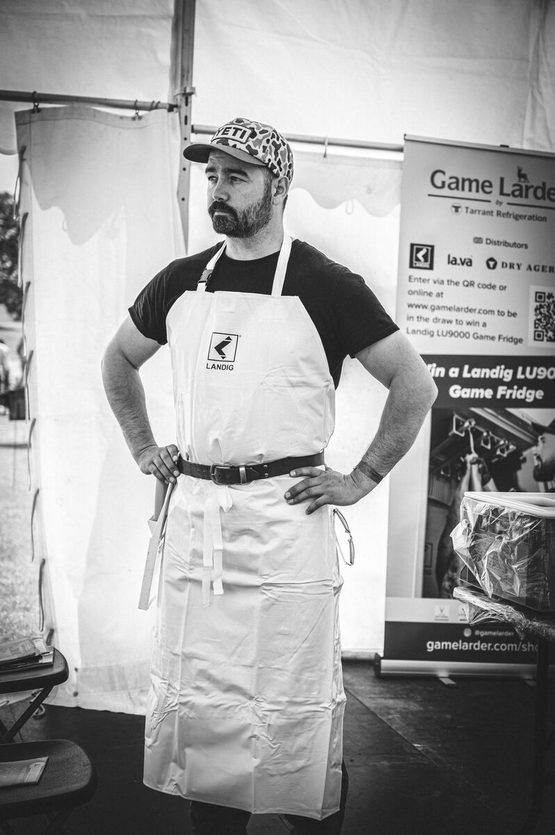 Cai Ap Bryn in the workshop marquee with butcher's apron and knife